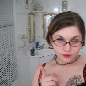 Frau mit Brille an Brust tätowiert