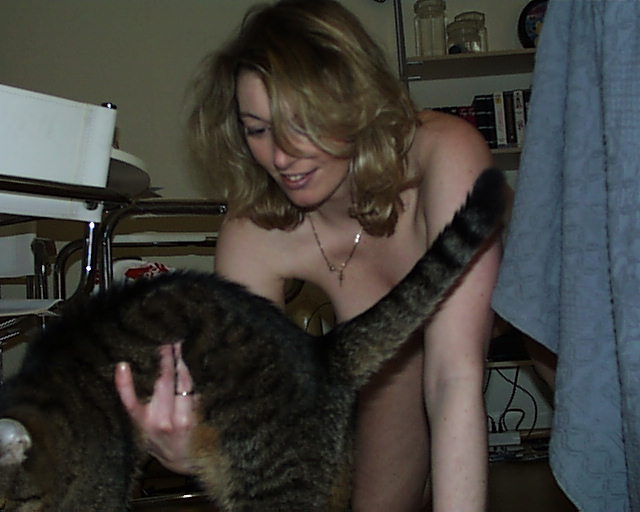 nackte Frau hebt Katze hoch